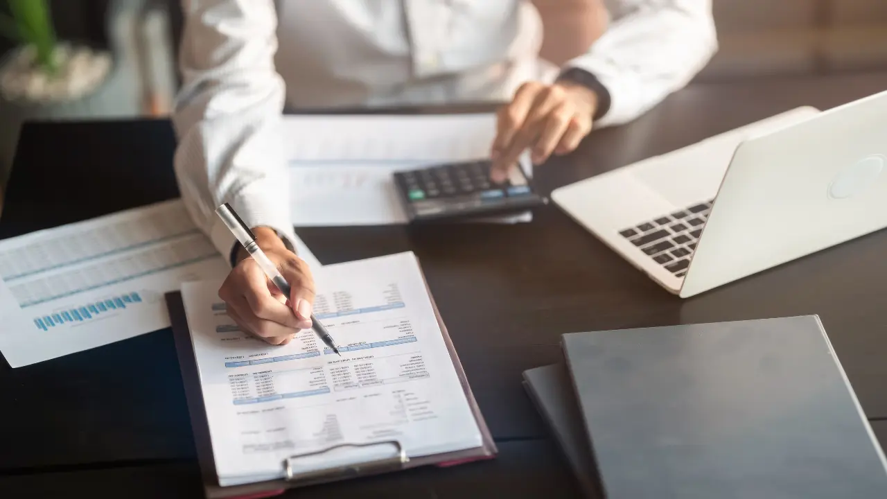 Analyse financière avec documents comptables, calculatrice et ordinateur pour estimer la valorisation et vendre son entreprise en 2026.